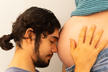Couple enjoying pregnancy showing their love on a white background