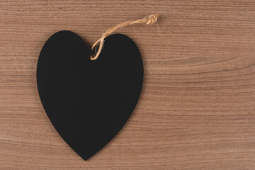 Black heart on wooden background.