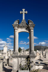 Fototapeta na wymiar A beautiful view of a cemetery graveyard with tombstones crosses and angels at llucmajor in mallorca island balearic spain on a clear sunny day 