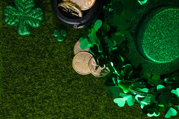 Festive composition for St. Patrick's Day with shiny hat of leprechaun with clover and coins on...