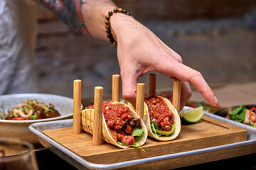 Traditional street mexican pork tacos with beef, tomatoes, avocado, chilli in yellow corn tortilla