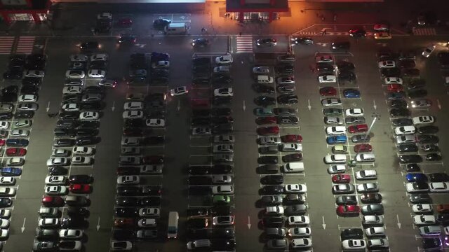 Aerial View Of The Supermarket (hypermarket Or Shopping Mall) Parking Lot With Lots Of Cars At Night