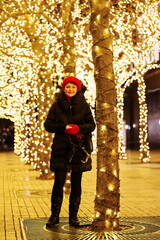 A woman is posing for a full-length portrait. It’s late at night and id dark outside. The...