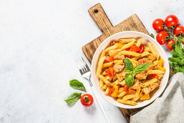 Pasta with chicken and vegetables at white kitchen table. Traditional italian food. Top view with...
