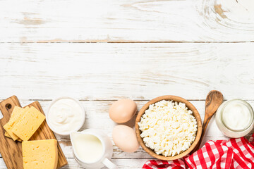 Dairy product at white wooden table. Curd, milk, yogurt, cheese and eggs. Organic farmer food. Top view with copy space.