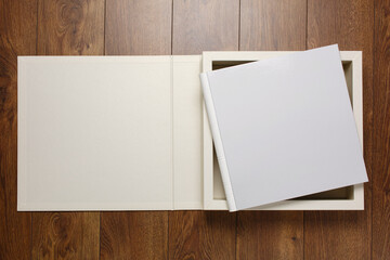 white wedding photo album on a wooden background with space for text.
white family photobook in...
