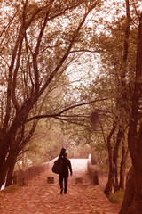 Young man carry guitar bag while walking alone through the forest. Enjoying in nature beauty