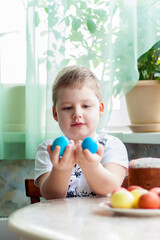 Portrait of a cute child with Easter eggs. Easter lunch. The feast of Holy Easter.