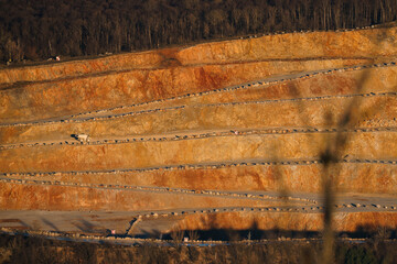 mining in a surface mine cut in a hill on a stone with a dump truck