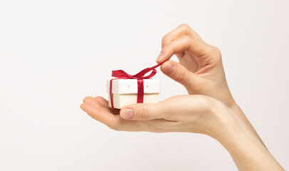 Female hands holding a luxury small gift box. isolated on white background. Christmas and New Year's day. Mock up template ready for your design.