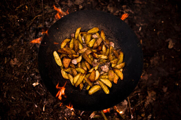 Fried potatoes in a frying pan, as well as tongues of flame that want to escape.