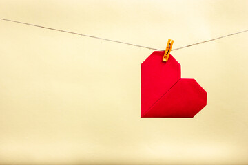 Red paper heart hanging on a rope.