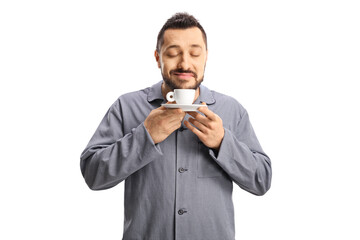 Man in pajamas smelling a cup of espresso coffee
