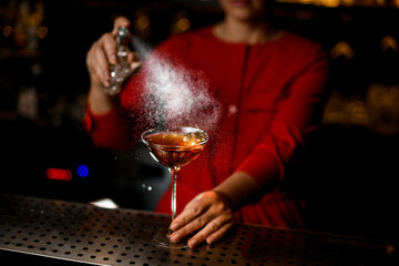 view of transparent glass with an alcoholic drink sprinkled on by bartender