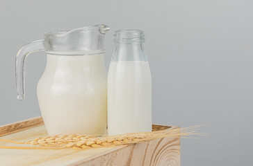 A jug and bottle of fresh milk glass on a wooden crate box. Raw milk is high in calcium and protein to drink for all ages. Milk consumption nutritious and healthy dairy products concept.