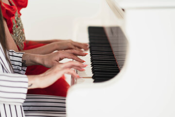 Fototapeta premium Mom and daughter play the piano