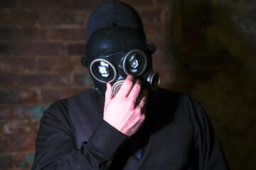 cosplay of a guy in a gas mask on a brick background with glowing eyes