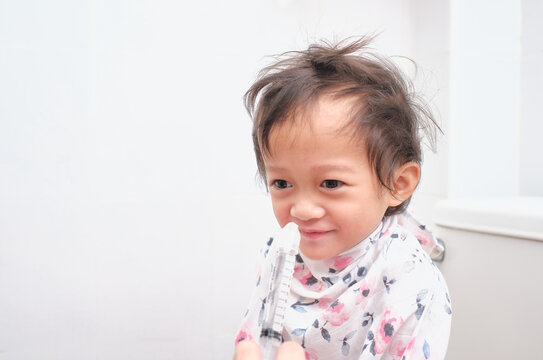 Asian Parent Flushing Her Sick Happy Little Toddler Baby Girl Child Nose With Syringe For Nasal Irrigation, Saltwater Washes - Selective Focus At Kid's Right Eye