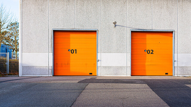 concrete wall with two orange gates
