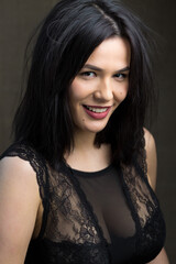 Fototapeta premium Portrait of a young sexy brunette girl in a lace top in dramatic tones. Vintage photo.