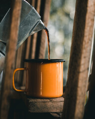 pouring coffee into an enamel mug