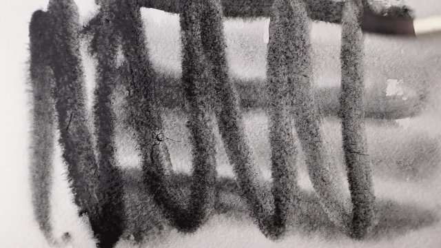 brush strokes of watercolor black paint with stains on a sheet of white paper.