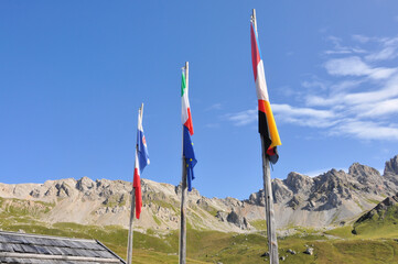 Flagi europejskich krajów powiewają nad górami w Dolomitach - obrazy, fototapety, plakaty