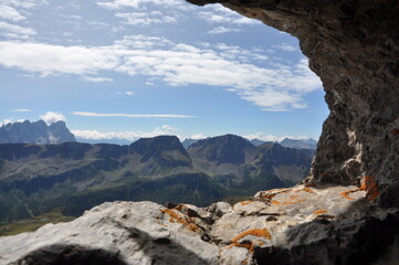 Widok na górskie szczyty włoskich Dolomitów ze skalnego okna - obrazy, fototapety, plakaty