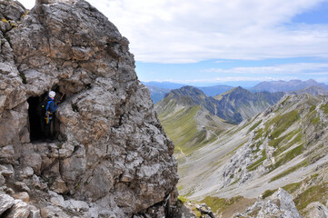 Męzczyzna podziwia górskie widoki z okna wydrążonego w skale, Dolomity - obrazy, fototapety, plakaty