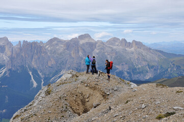 People are standing on the top of  a mountain in Dolomites, Italy