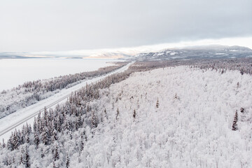 Fototapeta na wymiar Drone, aerial footage of the view above a wilderness, wild area, country in rural Canada, Yukon Territory with huge frozen lake. Great for home, office art or decor and prints. 
