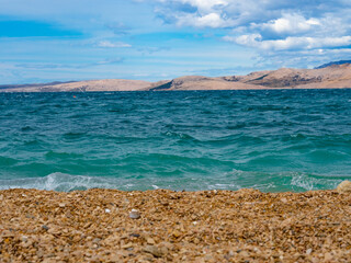 A blue beach in a mountainous bay.