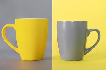 Yellow cup on gray and gray cup on yellow background. Colors of the Year 2021 Pantone Illuminating and Ultimate gray.