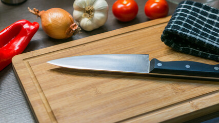 big kitchen Knife on cutting board with vegetables