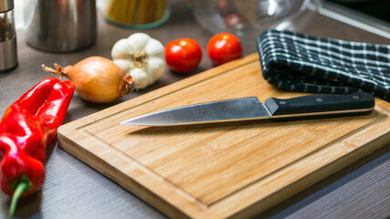 big kitchen Knife on cutting board with vegetables