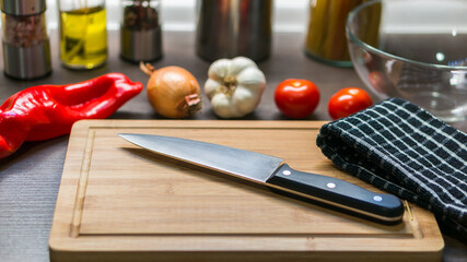 big kitchen Knife on cutting board with vegetables