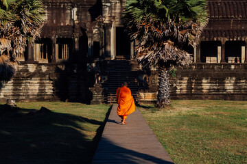 Buddhist monk walking past a temple at Angkor Wat, Siem Reap