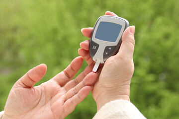 female hands close-up, a woman checks the blood sugar level with a glucometer, medical concept, blood glucose control, diabetes