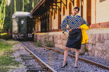 Fototapeta premium Young girl in vintage clothes at old train station