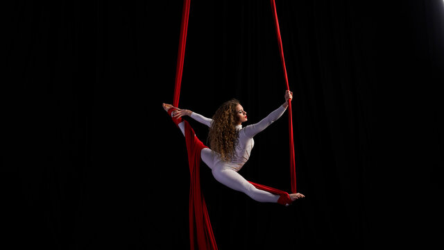 aerial girl professional circus performer performs acrobatic elements twist, flexibility, grace