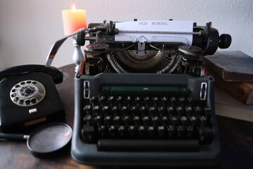 typewriter on table, words fake news are printed on paper in large size, candle is burning, retro...