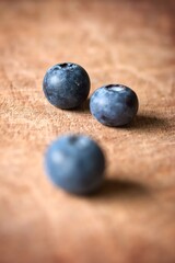 A close up shot of some fresh juicy blueberries on a wooden cutting board.