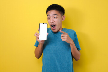 Excited Young Asian man shock showing phone screen at camera pointing at white phone screen