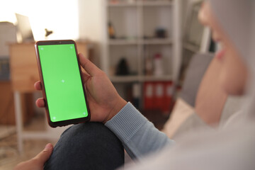 Close up image of smart phone mockup, woman holding phone with green screen