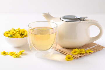 Organic Chrysanthemum flower tea in a cup and teapot on white background, Healthy Herbal drink