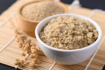 Cooked brown quinoa seeds and raw quinoa seeds in a bowl, Healthy vegan food