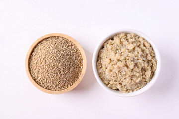 Cooked brown quinoa seeds and raw quinoa seeds in a bowl on white background, Healthy vegan food