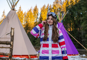 Portrait of Happy Pretty Caucasian woman in ski outfit and With Snowboarding Mask on her Head. Portrait of cheerful blond woman at ski resort