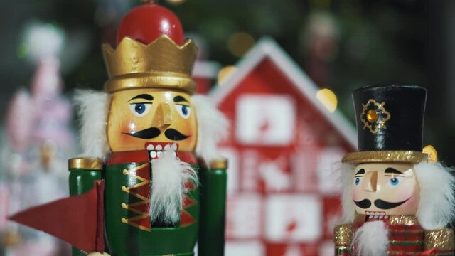 Wooden Tree Advent Calendar in Front of a Real Christmas Tree Decorated Nutcracker Soldier Toys. Fairy Lights on a Christmas Tree With Blurred Background. 4K Static Shot.