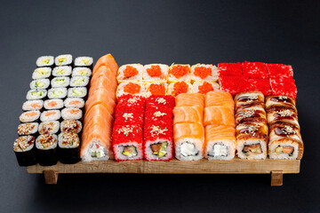 Full huge set of all types of classic japanese sushi rolls on a big wooden board, top view